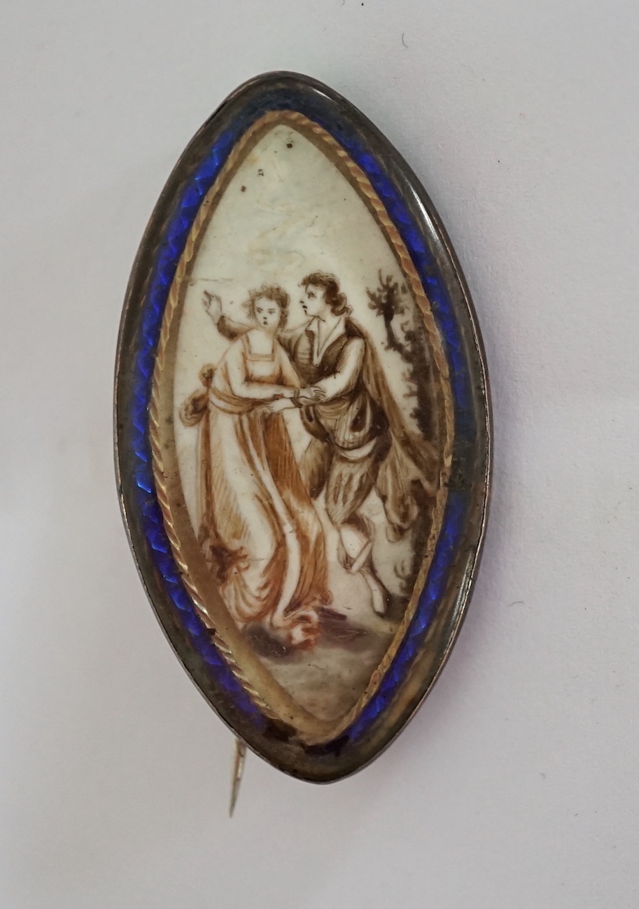 A Regency yellow metal and blue enamel mounted navette shaped pendant brooch, with inset ivory panel decorated with a lady and gentleman, 43mm. CITES Submission reference GAF52XTV